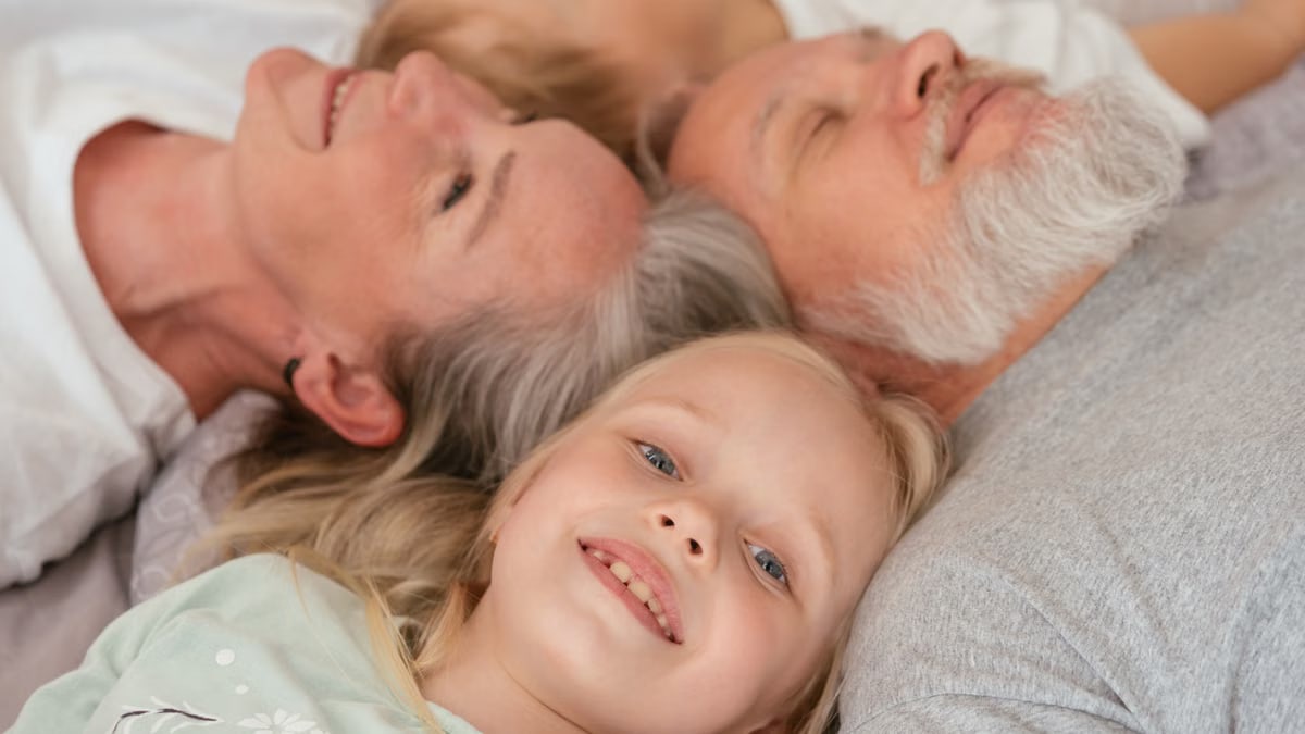 A joyful multigenerational family lying together and smiling, illustrating love and togetherness.